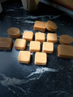 A set of natural face soaps arranged on a dark, polished marble surface.